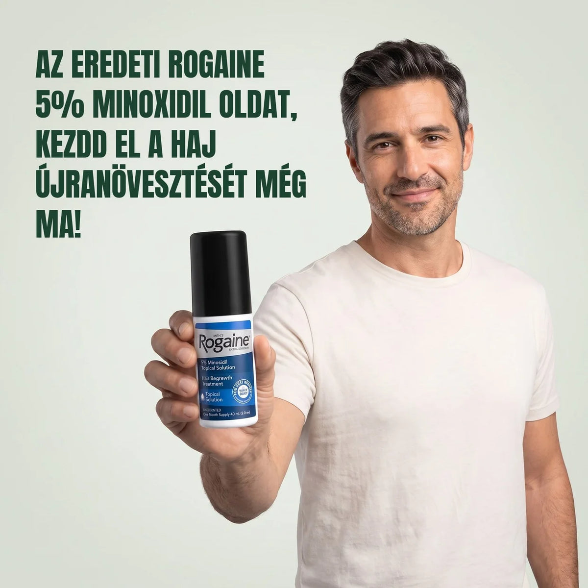 Smiling man holding a bottle of Rogaine 5% Minoxidil hair regrowth solution.